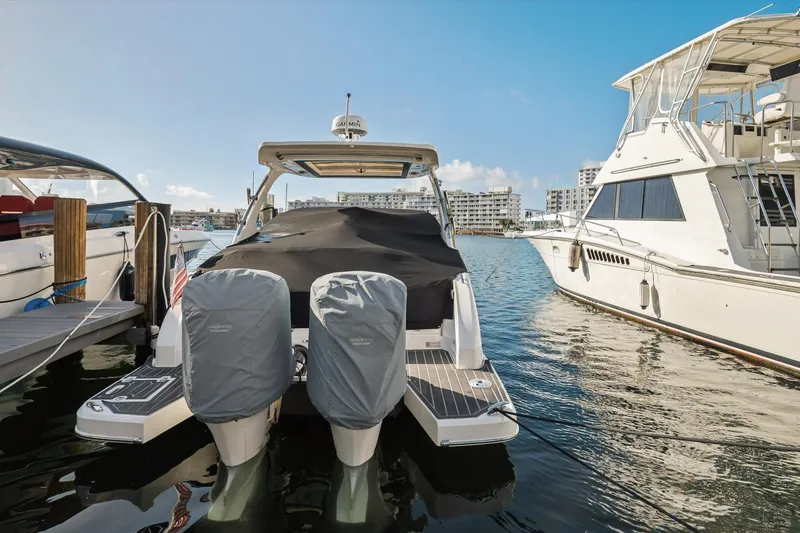 Slide: The Image of 2019 Regal 33 OBX boat docked at marina with covered engines. - 32