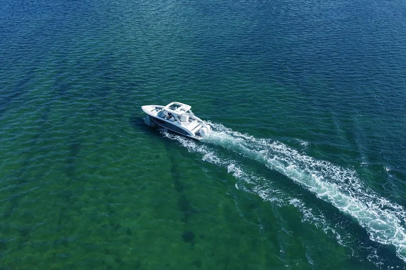 Slide: The Image of Aerial view of 2019 Regal 33 OBX boat cruising on clear blue water. - 33