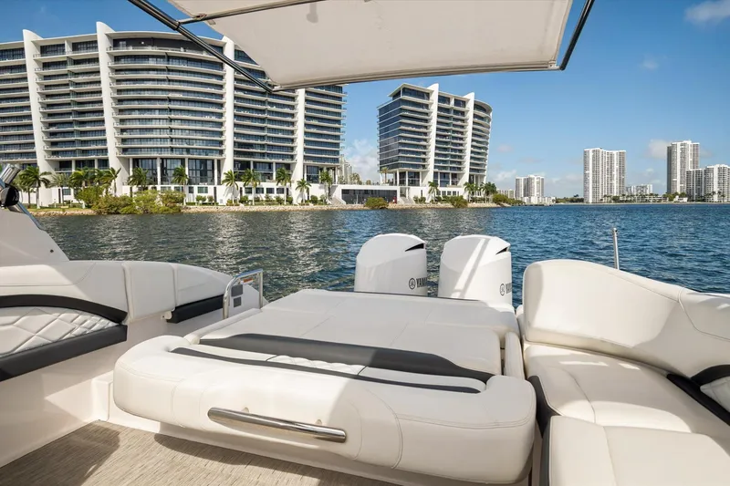 Slide: The Image of 2019 Regal 33 OBX boat with luxury seating, city skyline, and waterfront view. - 8