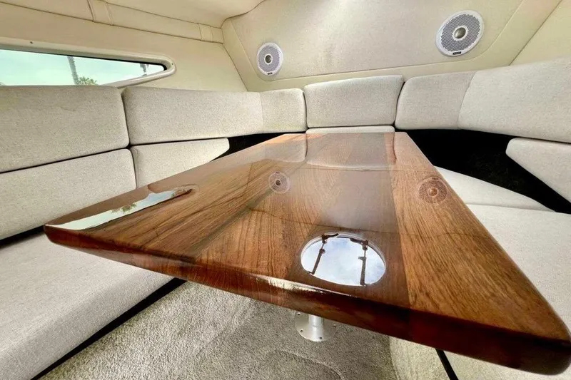 Slide: The Image of Luxurious interior of 2019 Regal 26 XO boat with polished wood table and cushioned seating. - 10