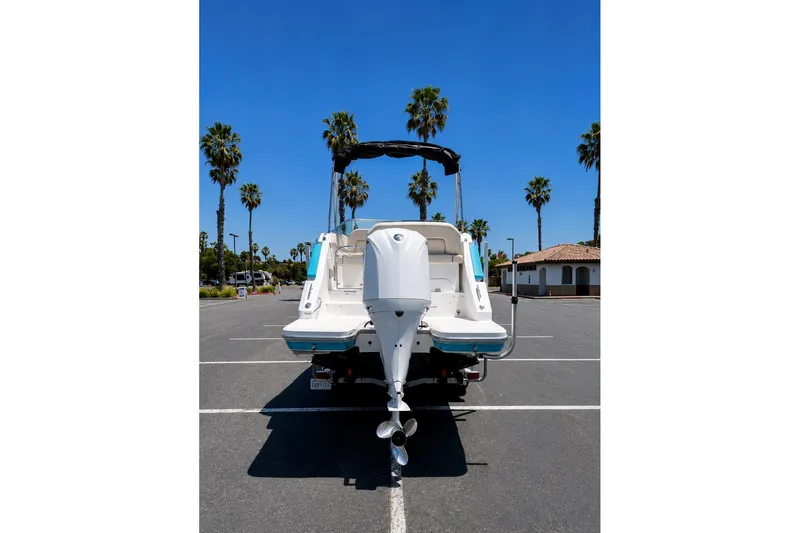 Slide: The Image of 2019 Regal 26 XO boat parked, rear view, with palm trees and clear blue sky. - 3