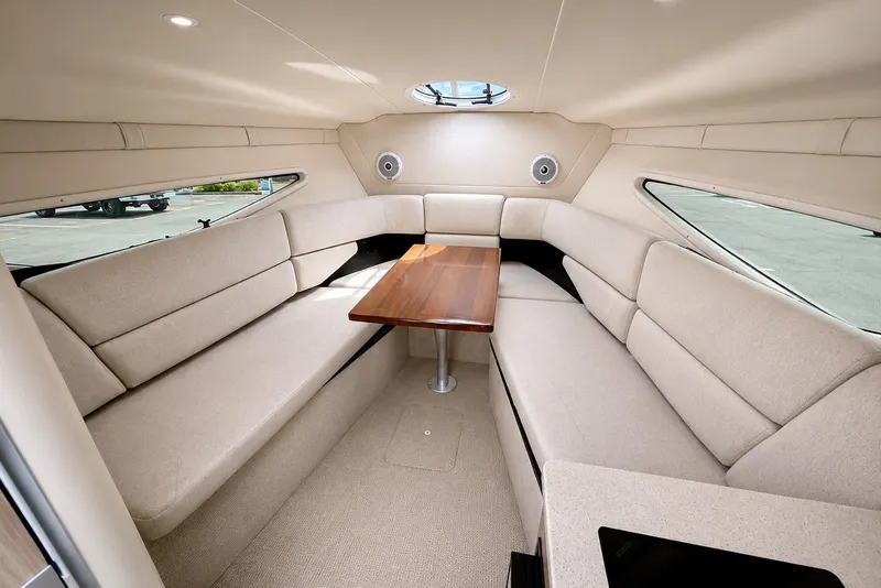 Slide: The Image of Interior of 2019 Regal 26 XO boat with beige seating and wooden table. - 9