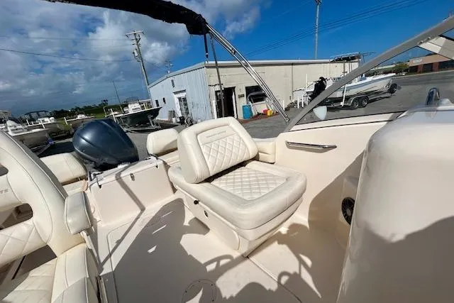 Slide: The Image of 2022 Grady-White Freedom 215 boat interior with cushioned seating and steering console. - 12