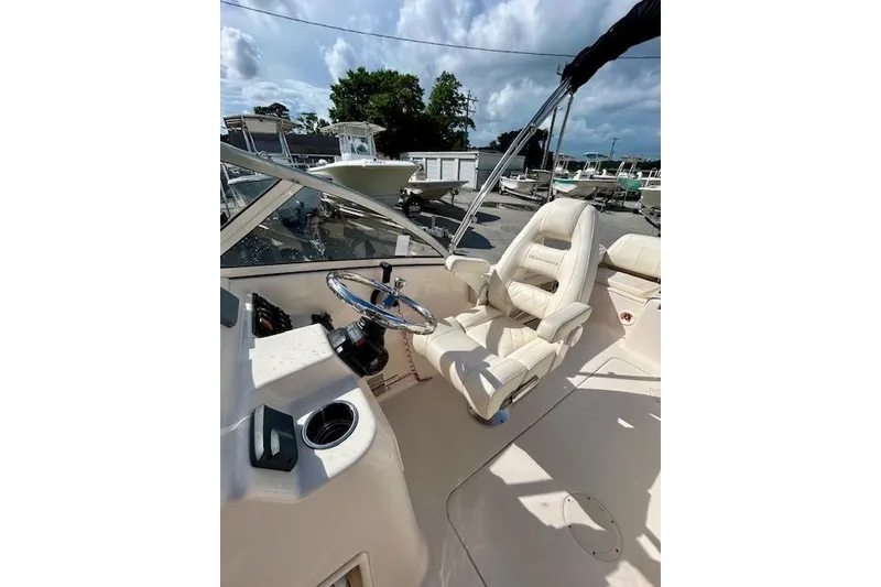 Slide: The Image of 2022 Grady-White Freedom 215 boat interior with steering wheel and captain's chair. - 13