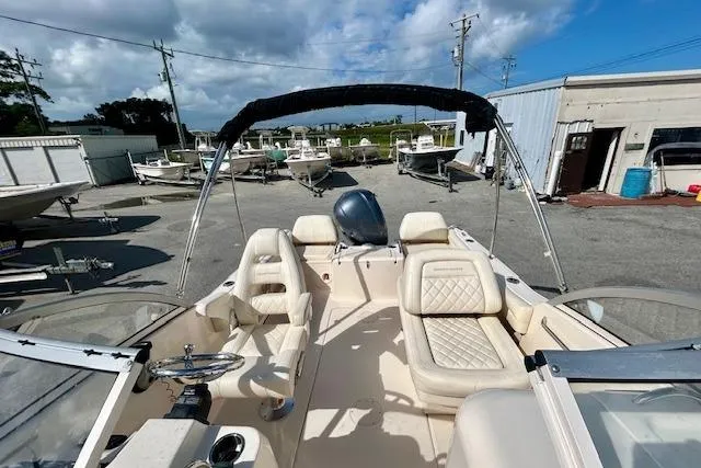 Slide: The Image of 2022 Grady-White Freedom 215 boat interior with seating, parked outdoors under a blue sky. - 14
