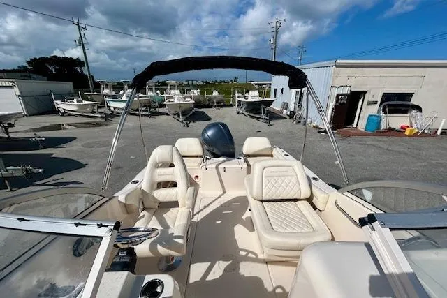 Slide: The Image of 2022 Grady-White Freedom 215 boat with seating, parked in a marina under a cloudy sky. - 15