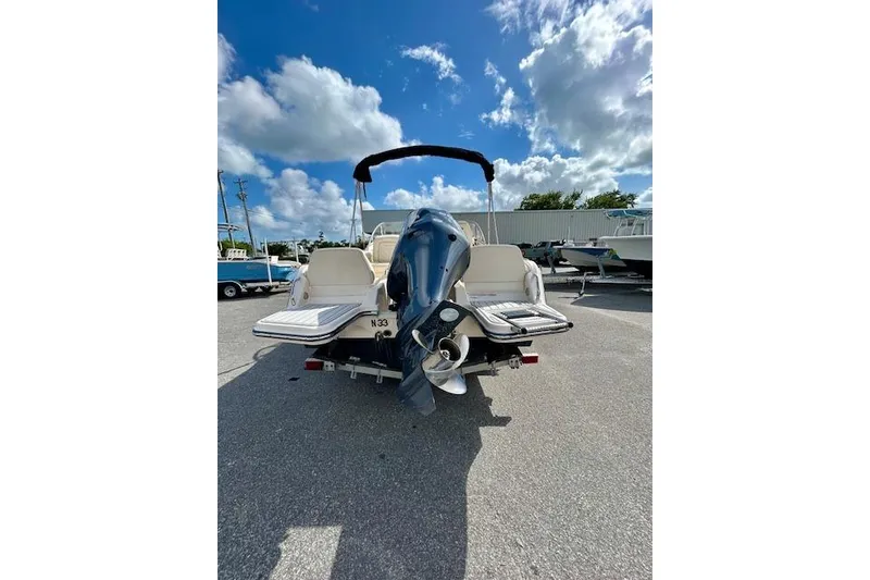 Slide: The Image of 2022 Grady-White Freedom 215 boat with outboard motor, parked under a blue sky. - 17