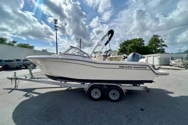 Slide: The Image of 2022 Grady-White Freedom 215 boat on trailer under cloudy sky. - 2