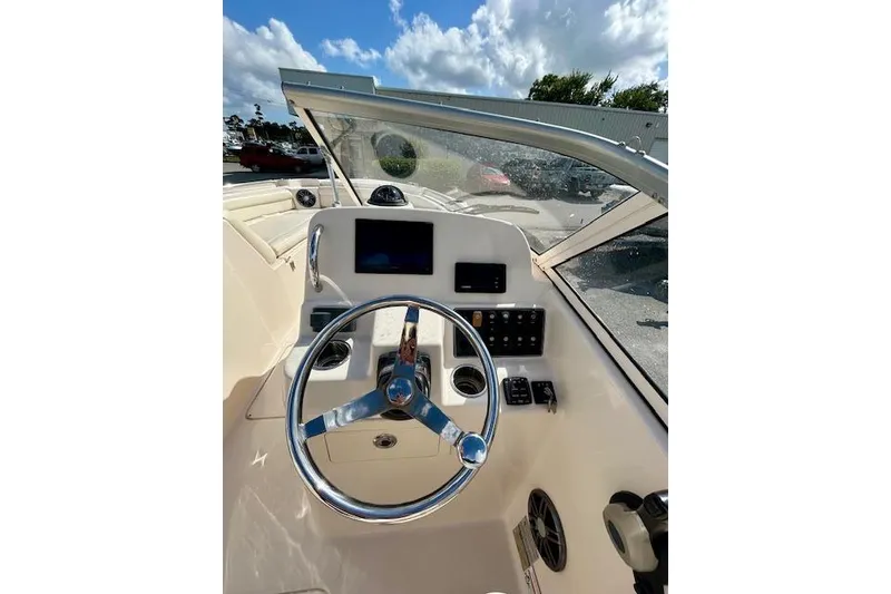 Slide: The Image of 2022 Grady-White Freedom 215 boat dashboard with steering wheel and controls. - 4
