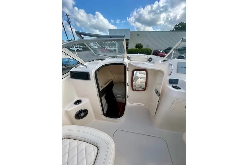 Slide: The Image of 2022 Grady-White Freedom 215 boat interior with open cabin door under a blue sky. - 7