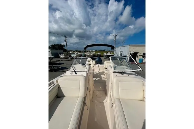 Slide: The Image of 2022 Grady-White Freedom 215 boat with spacious seating, docked under a partly cloudy sky. - 8