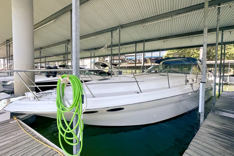 The Image of 2001 Sea Ray 410 Sundancer docked in a covered marina slip. - 0
