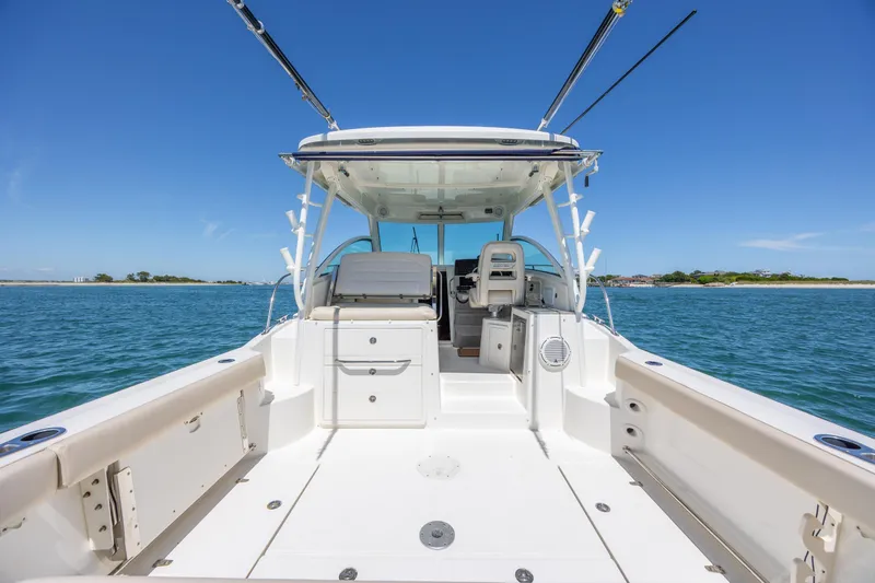 Slide: The Image of 2017 Boston Whaler 315 Conquest boat on open water, showcasing spacious deck and seating. - 14