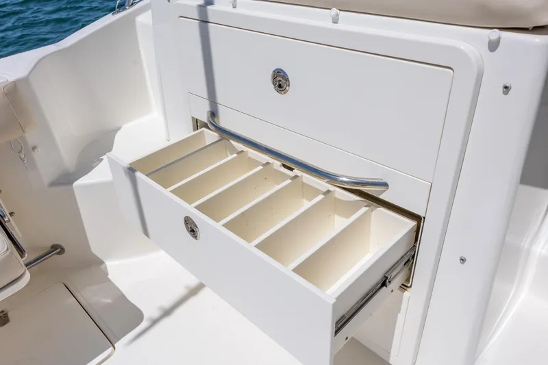Slide: The Image of 2017 Boston Whaler 315 Conquest boat storage compartment with open drawer and dividers. - 17