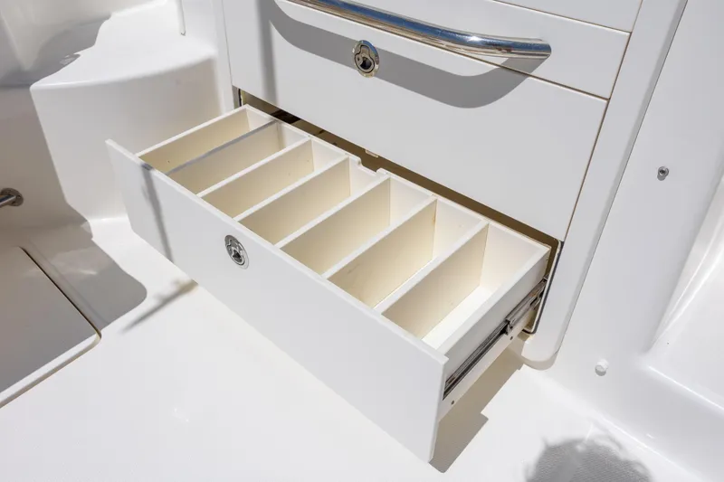 Slide: The Image of Open storage drawer on 2017 Boston Whaler 315 Conquest boat, featuring multiple compartments. - 18