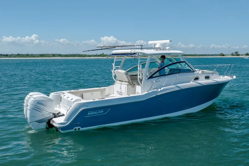 Slide: The Image of 2017 Boston Whaler 315 Conquest boat cruising on clear blue water. - 2