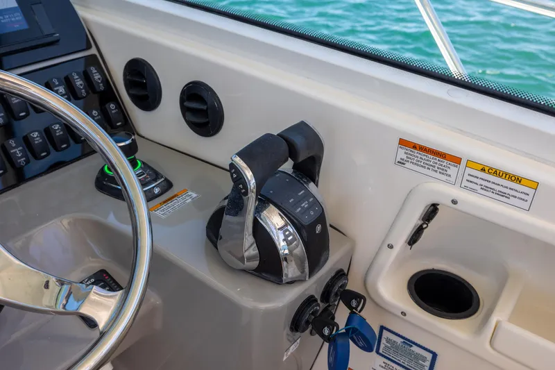 Slide: The Image of Control panel of a 2017 Boston Whaler 315 Conquest boat with steering wheel and throttle. - 27