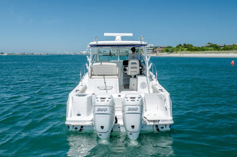 Slide: The Image of 2017 Boston Whaler 315 Conquest boat on clear blue water, rear view. - 3