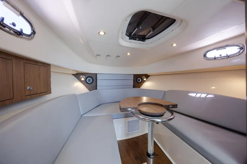 Slide: The Image of Interior of 2017 Boston Whaler 315 Conquest, featuring a cozy seating area and wooden table. - 31