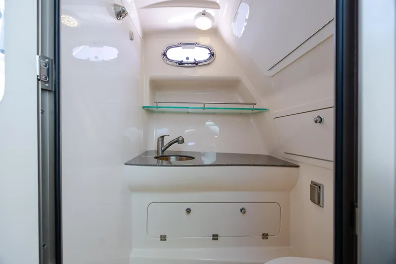 Slide: The Image of 2017 Boston Whaler 315 Conquest boat interior bathroom with sink and storage. - 33