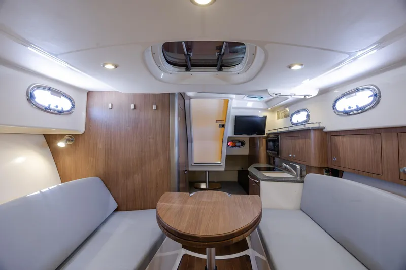 Slide: The Image of Interior of 2017 Boston Whaler 315 Conquest boat with seating, table, and kitchenette. - 35