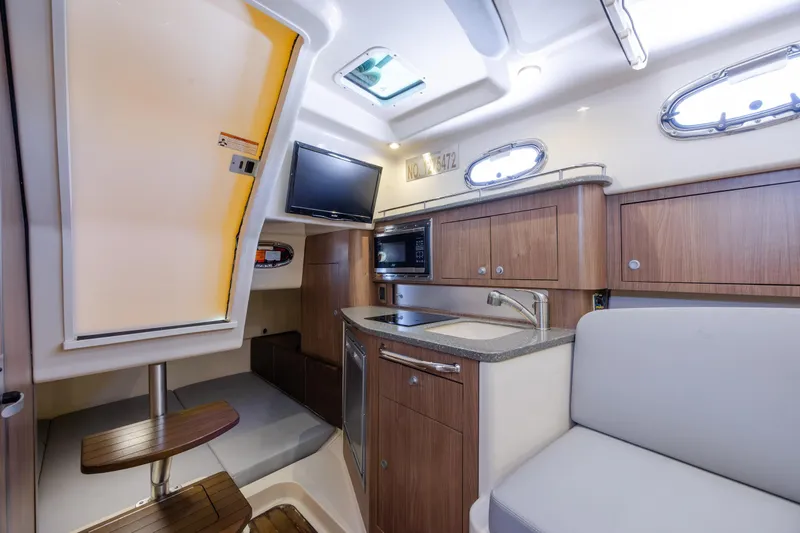 Slide: The Image of Interior of 2017 Boston Whaler 315 Conquest boat with kitchenette and seating area. - 36