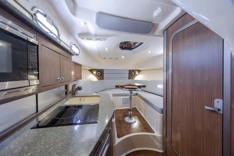 Slide: The Image of Interior of 2017 Boston Whaler 315 Conquest, featuring modern kitchen and cozy seating area. - 38
