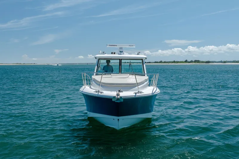 Slide: The Image of 2017 Boston Whaler 315 Conquest boat on open water under clear blue sky. - 8