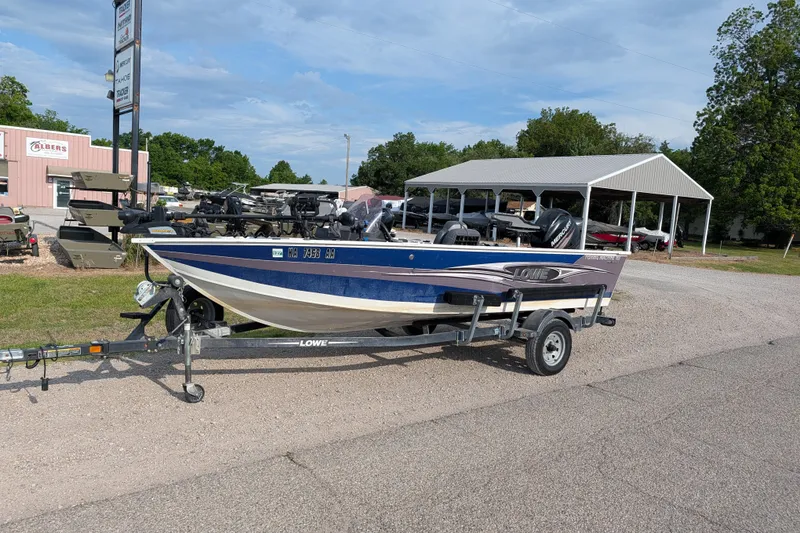 The Image of 2017 Lowe Fishing Machine 165SC Pro on trailer, parked outdoors near dealership. - 1