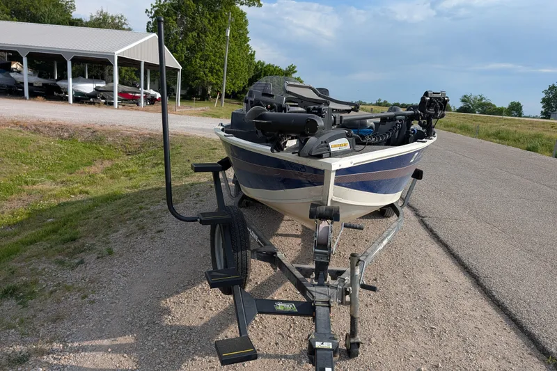 Slide: The Image of 2017 Lowe Fishing Machine 165SC Pro on trailer, parked near boat storage area. - 12