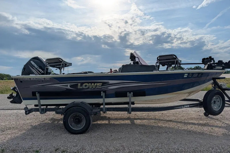 Slide: The Image of 2017 Lowe Fishing Machine 165SC Pro boat on trailer under cloudy sky. - 8