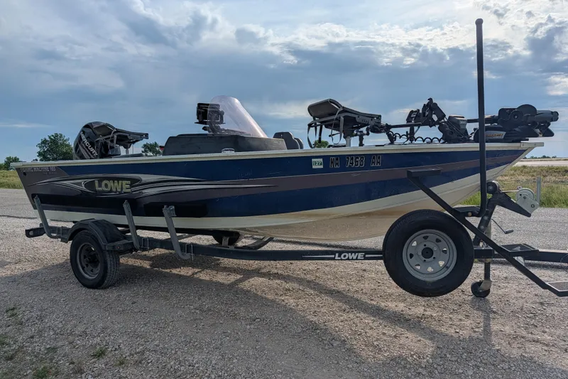Slide: The Image of 2017 Lowe Fishing Machine 165SC Pro boat on trailer under cloudy sky. - 9