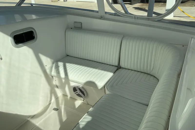 Slide: The Image of 2005 Intrepid 348 Walkaround boat interior with white cushioned seating. - 11
