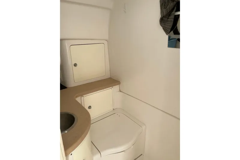Slide: The Image of 2005 Intrepid 348 Walkaround boat interior with compact bathroom and storage cabinets. - 16