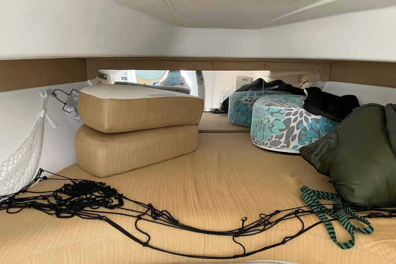 Slide: The Image of 2005 Intrepid 348 Walkaround cabin interior with cushions and storage items. - 18