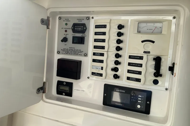 Slide: The Image of Electrical control panel of a 2005 Intrepid 348 Walkaround boat, featuring various switches and gauges. - 19