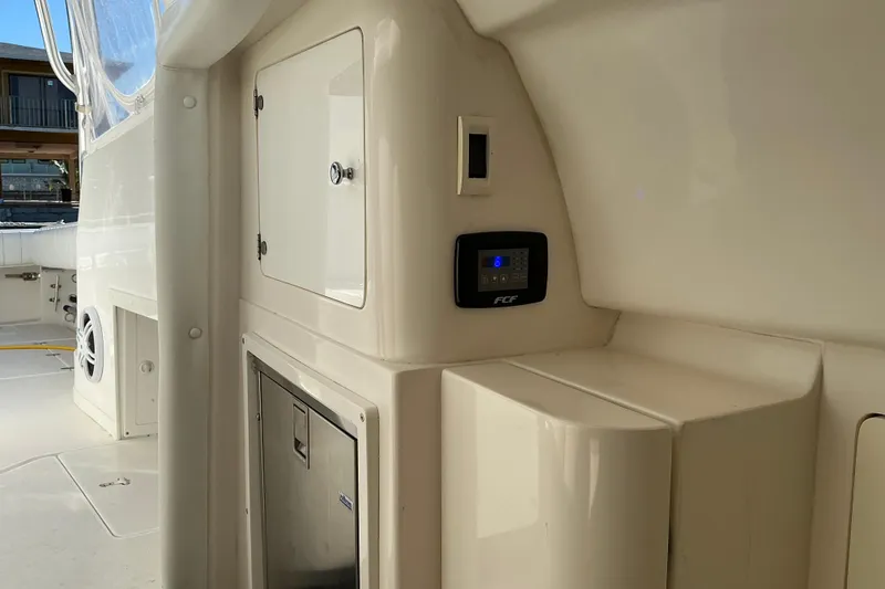 Slide: The Image of 2005 Intrepid 348 Walkaround boat interior with control panel and storage compartments. - 20