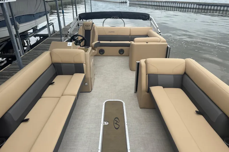 Slide: The Image of 2022 Harris Sunliner 250 pontoon boat interior with beige seating and steering console. - 13