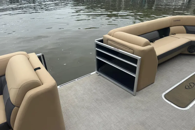 Slide: The Image of 2022 Harris Sunliner 250 pontoon boat with beige seating on calm water. - 15