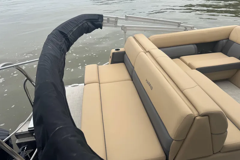 Slide: The Image of 2022 Harris Sunliner 250 boat with beige seating on calm water. - 19
