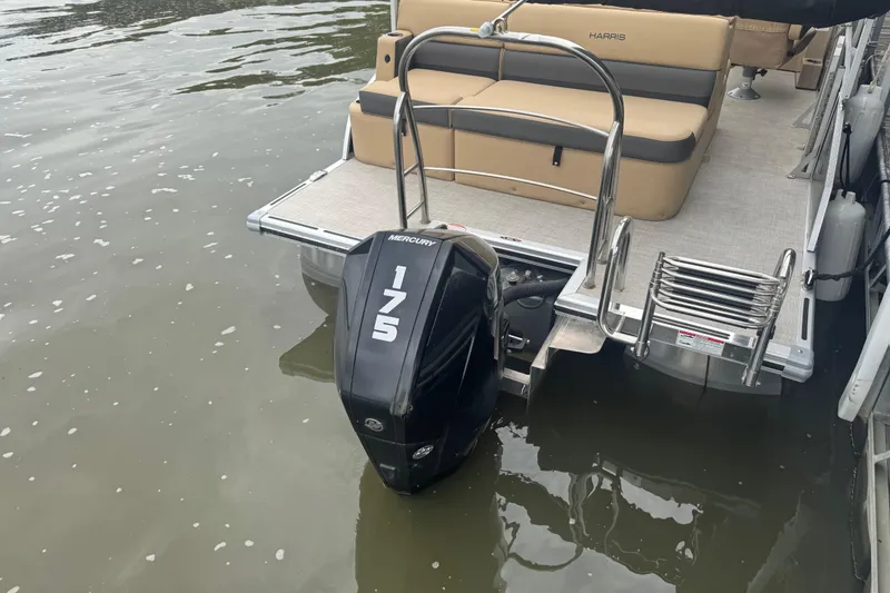 Slide: The Image of 2022 Harris Sunliner 250 pontoon boat with Mercury 175 outboard motor on water. - 20