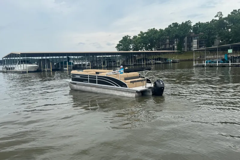 Slide: The Image of 2022 Harris Sunliner 250 pontoon boat on a calm lake near docks. - 5