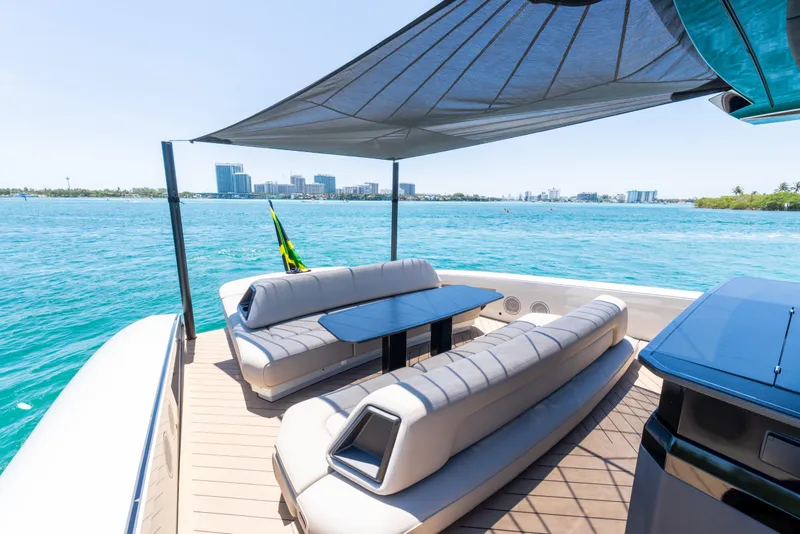 Slide: The Image of Luxurious 2025 Wajer 77 yacht deck with seating, overlooking serene blue waters and city skyline. - 18