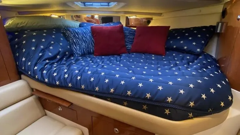 Slide: The Image of Interior of 2007 Regal 3360 Window Express with cozy bed and star-patterned bedding. - 26