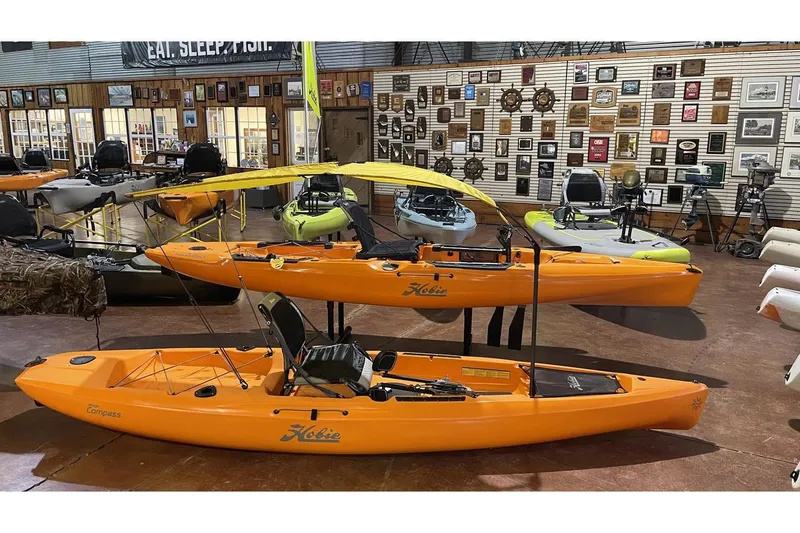 Slide: The Image of 2022 Hobie Mirage Compass kayaks displayed in a showroom. - 4