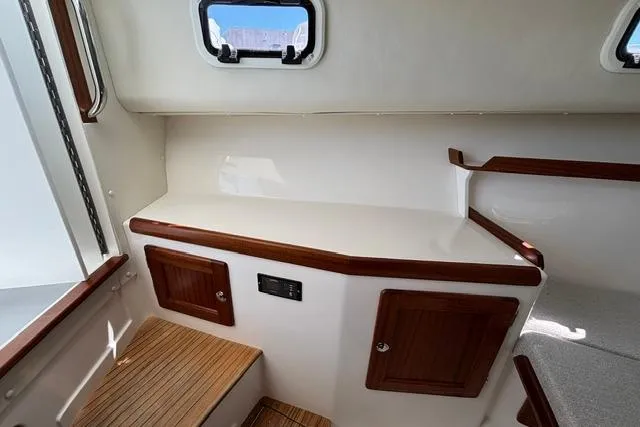 Slide: The Image of Interior of 2026 NorthCoast 285 HT boat, featuring wooden accents and compact storage. - 10