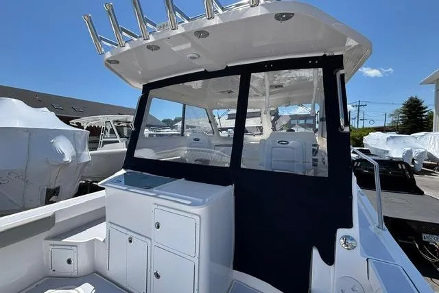 Slide: The Image of 2026 NorthCoast 285 HT boat with enclosed cockpit and rod holders under clear blue sky. - 5
