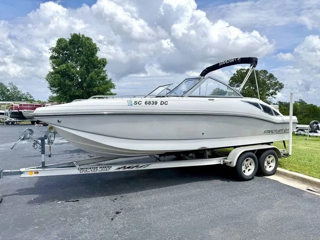 The Image of 2015 Starcraft 210 I/O SCX boat on trailer, cloudy sky. - 1