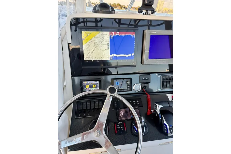 Slide: The Image of 2008 Jupiter 38 FS boat dashboard with navigation screens and steering wheel. - 14