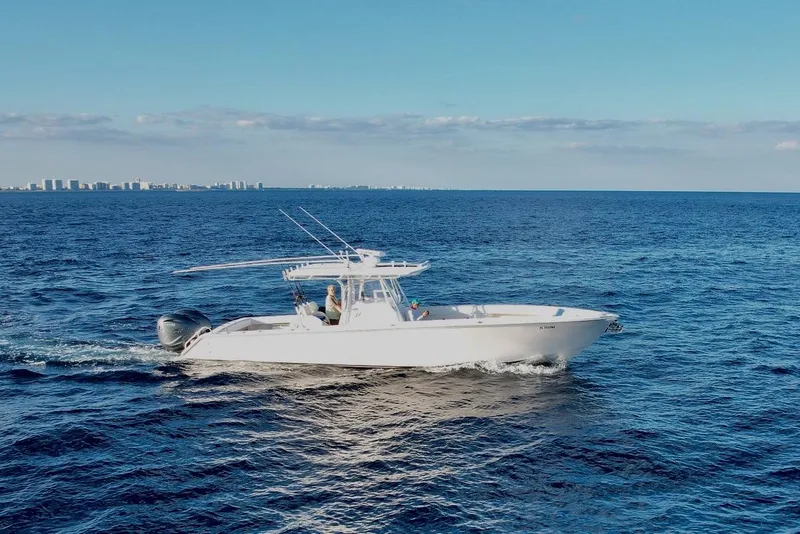 Slide: The Image of 2008 Jupiter 38 FS boat cruising on open ocean with city skyline in background. - 2